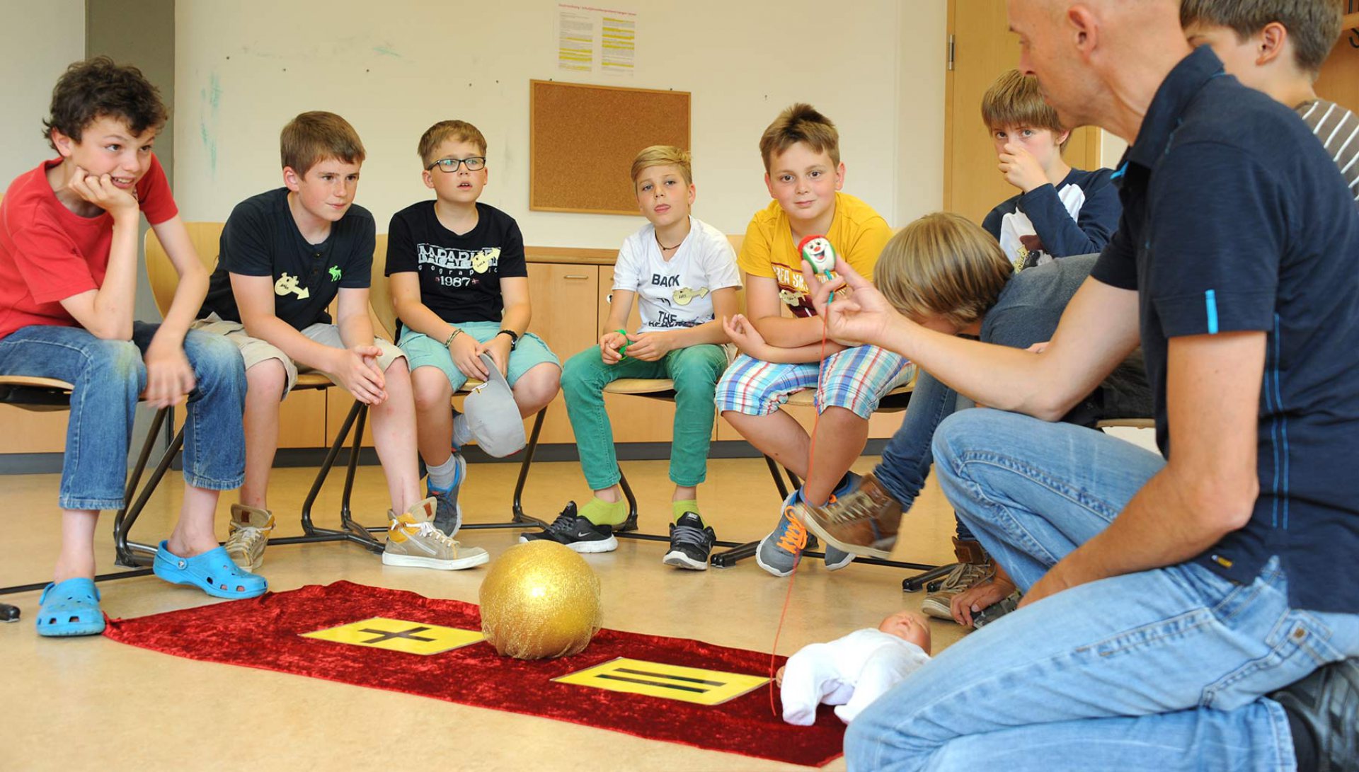 Jungen sitzen im Workshop Agenten auf dem Weg im Kreis um das Spielfeld
