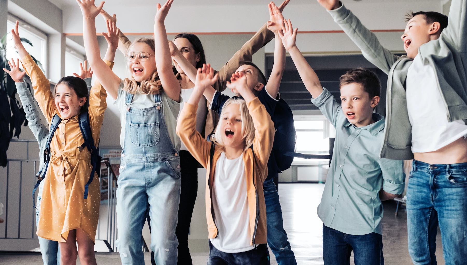 Jugendliche jubeln gemeinsam in einem Klassenraum